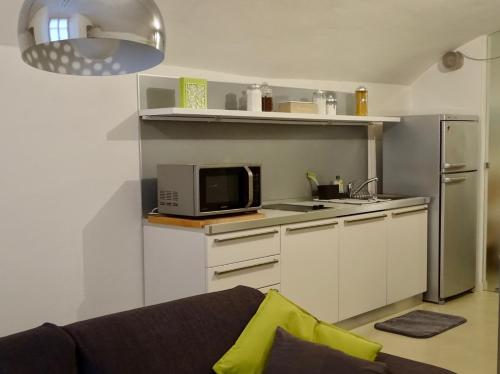 uma pequena cozinha com um micro-ondas e um frigorífico em Cavour 96 em Mântua