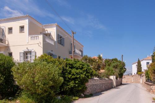 a white house on a street with bushes at Mimoza in Spetses