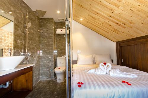 a bedroom with a bed and a sink and a shower at Lagoon Homestay Hoi An in Hoi An
