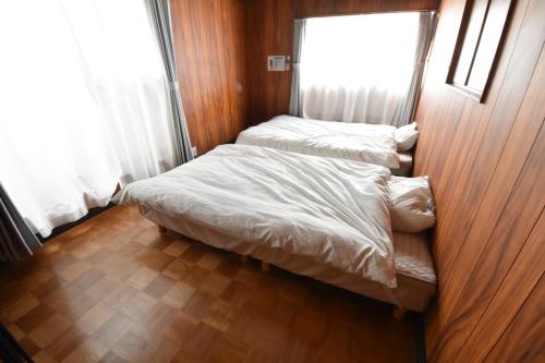 two beds in a small room with a window at CRAFT in Matsubara