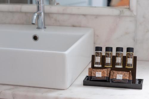 a bathroom sink with five bottles of essential oils at Mimoza in Spetses