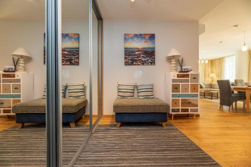 a room with two beds and a living room at Simpsono apartamentai №215 in Palanga