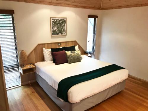 a bedroom with a large bed with pillows on it at Ellensbrook Cottages in Cowaramup