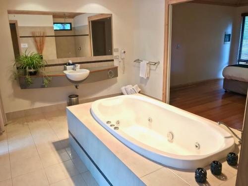 a large bathroom with a tub and a sink at Ellensbrook Cottages in Cowaramup