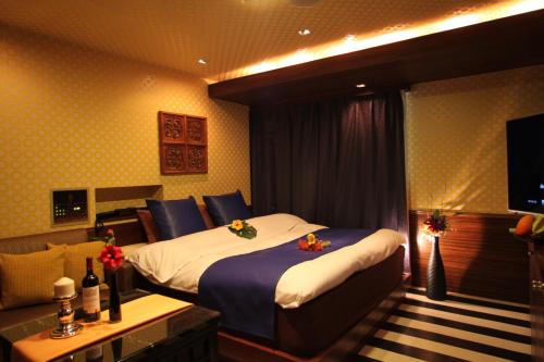 a hotel room with a bed and a television at Hotel Water Gate Narita (Adult Only) in Narita