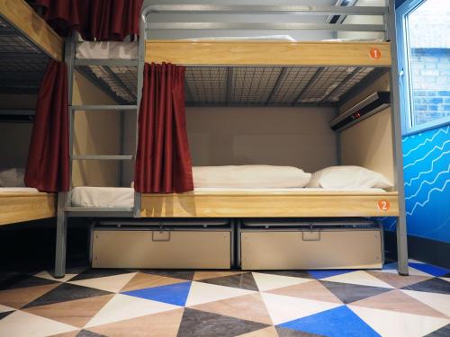 a bunk bed in a room with a checkered floor at St Christopher's Liverpool Street in London