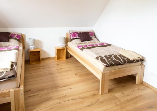 a bedroom with two bunk beds and wooden floors at Chata Hrozenka WELLNESS in Nový Hrozenkov