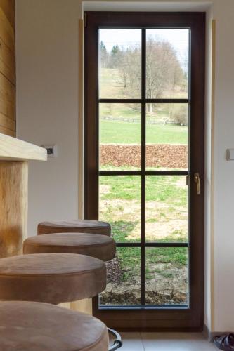 a row of stools in a room with a window at Chata Hrozenka WELLNESS in Nový Hrozenkov