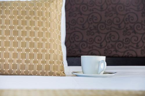 a coffee cup sitting on a table next to a pillow at Comfort Inn On Raglan in Warrnambool