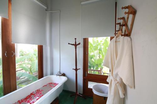 a bathroom with a bath tub and a cross on the wall at BaanSuk Sukhothai Resort in Sukhothai