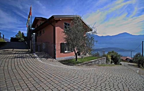 a building with a flag on the side of a road at La Collina degli Ulivi in Vercana