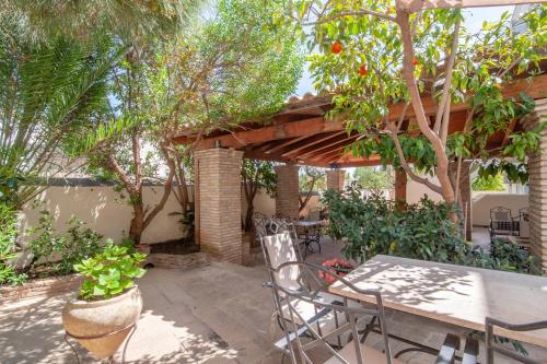 a patio with a table and chairs and trees at Mimoza in Spetses
