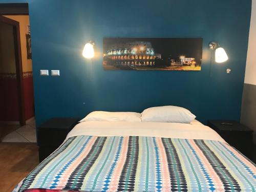 1 dormitorio con 1 cama con pared azul en La Casa di Elena, en Roma