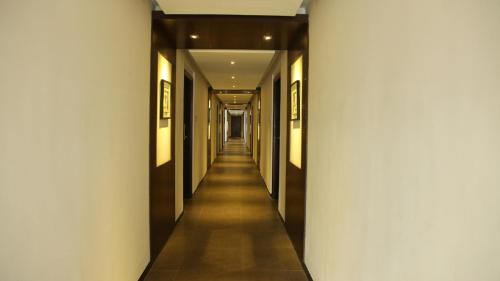 a hallway in a building with white walls and a long corridor at THE PEBBLE Boutique Hotel in Tiruppūr