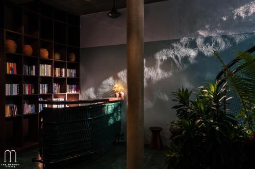 a room with bookshelves and a table with a lamp at The Memory - Danang in Da Nang