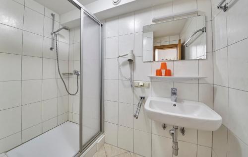 a white bathroom with a sink and a shower at Ski & Bike Appartements Forsthaus in Saalbach Hinterglemm