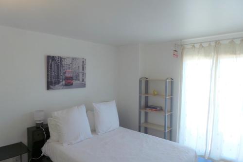 - une chambre avec un lit blanc et un bus rouge dans l'établissement Spacious and bright flat Downtown and Beaches - Swimming Pool, à Antibes