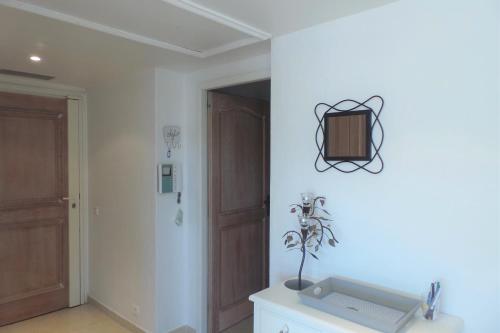 Cette chambre blanche dispose d'un lavabo et d'une porte. dans l'établissement Spacious and bright flat Downtown and Beaches - Swimming Pool, à Antibes