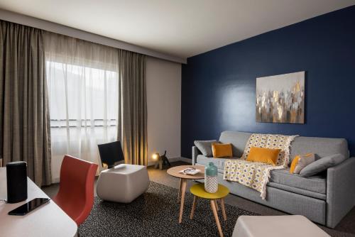 a living room with blue walls and a couch at Aparthotel Adagio La Défense Esplanade in Puteaux
