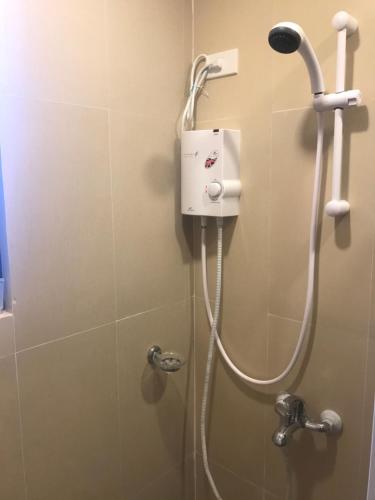 La salle de bains est pourvue d'une douche avec un pommeau de douche. dans l'établissement Babylon Oslob Coast Guesthouse, à Oslob