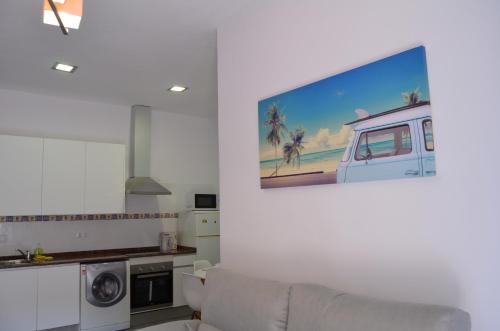 a living room with a couch and a tv on a wall at Apartament Piramide Complex Alicante Beach in Alicante