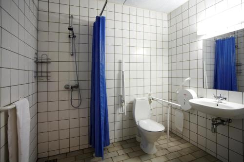 
a bathroom with a toilet, sink, and shower stall at Danhostel Ringkøbing in Ringkøbing
