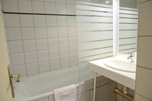 y baño con ducha y lavamanos. en Hotel Restaurant Rolland en Montagnieu
