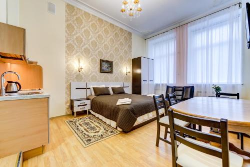 a bedroom with a bed and a dining room at Guest rooms on Kirochnaya 22 in Saint Petersburg