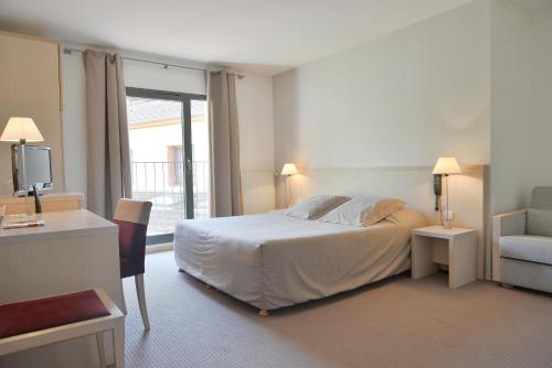 Habitación de hotel con cama y silla en Hotel Restaurant Rolland en Montagnieu