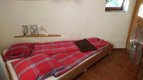 - une chambre avec un lit et une couverture rouge dans l'établissement Volets rouges, à Mons