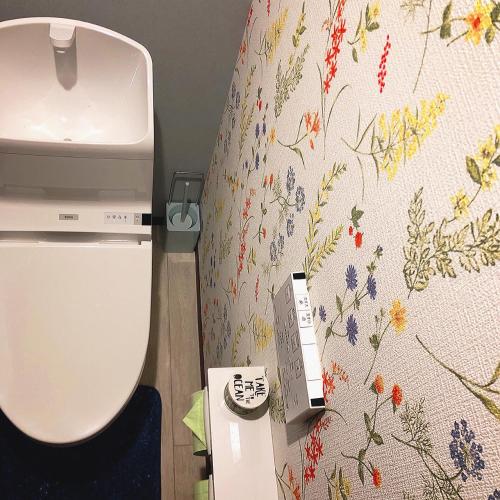 a bathroom with a toilet with a flowery wallpaper at Stay Nikko Guesthouse in Nikko