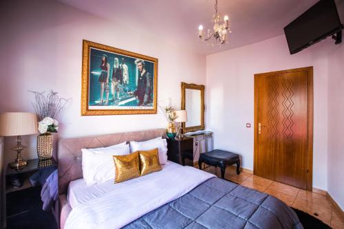 a bedroom with a bed and a painting on the wall at LUXURY SUITES - free parking in Drama