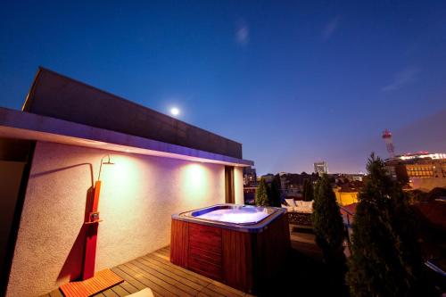 a hot tub on top of a balcony at night at Sarroglia Hotel in Bucharest