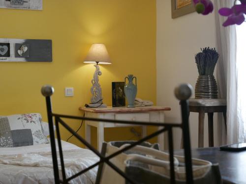a living room with a table with a lamp on it at Hotel Les Ambres in Roussillon