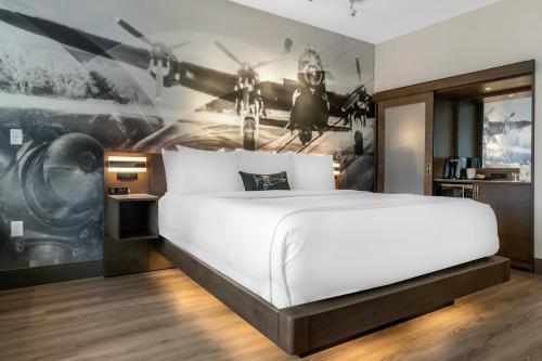 a bedroom with a large bed and a painting of planes at Cambria Hotel - Arundel Mills BWI Airport in Hanover