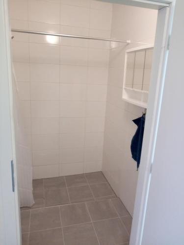a walk in shower in a bathroom with a tile floor at Apartmány Karviná in Karviná