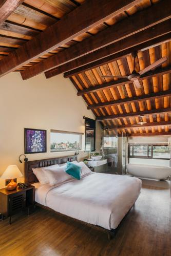 a bedroom with a large bed with a wooden ceiling at La An Central Boutique Villa in Hoi An