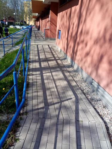 a sidewalk with a blue railing next to a building at Apartmány Karviná in Karviná