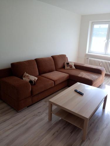 a living room with a brown couch and a coffee table at Apartmány Karviná in Karviná