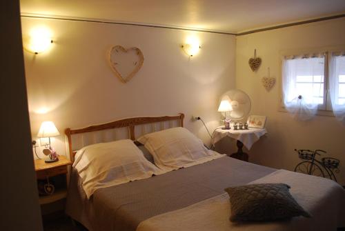 - une chambre avec un lit, deux tables et deux lampes dans l'établissement le pitchounet, à Arles