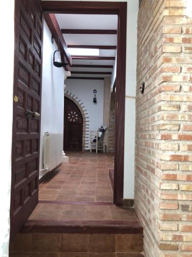 a hallway with a door and a brick wall at Retiro del Teatro Almagro in Almagro