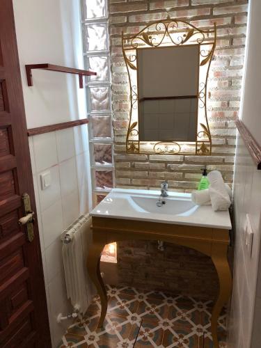 a bathroom with a sink and a mirror on a brick wall at Retiro del Teatro Almagro in Almagro