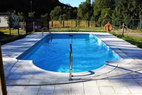 una piscina de agua azul en un patio en HOSTEL Backpacker SOLOPUENT, en Castiello de Jaca