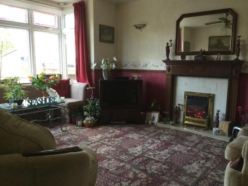 a living room with a fireplace and a mirror at Merlewood in Skegness