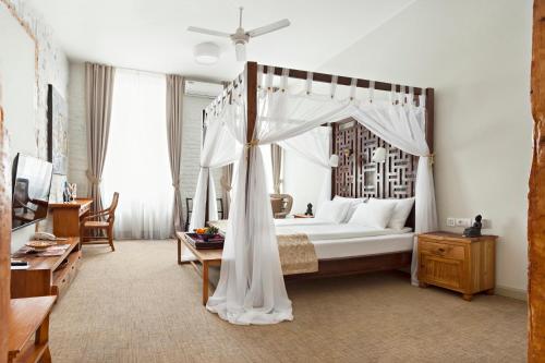 a bedroom with a canopy bed and a table at SuperB Luxury Suites in Belgrade
