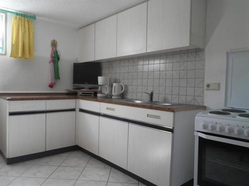 a kitchen with white cabinets and a sink and a stove at Ferienhaus Spitaler in Kleinboden