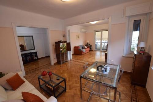 a living room with a couch and a glass table at Spacious & Sunny Kolonaki Apt 5 mins metro/ACx3/1.5 BT in Athens