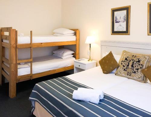 Zimmer mit 2 Betten und 1 Etagenbett in der Unterkunft Altona Lodge in Kapstadt