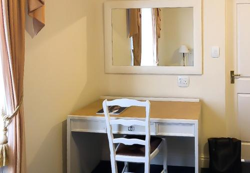 einen weißen Stuhl am Schreibtisch mit Spiegel in der Unterkunft Altona Lodge in Kapstadt