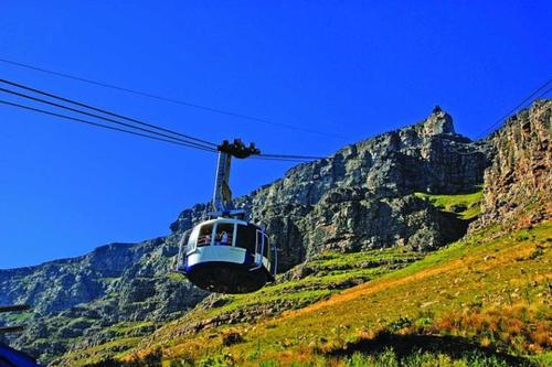 a cable car on a hill with a mountain at GORDON's SHORE LUXURY APARTMENTS - Solar Powered in Gordonʼs Bay